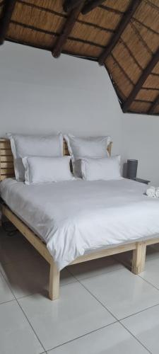 SandtonLAPA ROOF的一张带白色床单和枕头的床