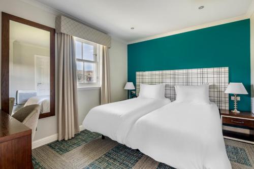 肯莫尔肯摩尔俱乐部钻石度假公寓的卧室配有一张白色大床和镜子