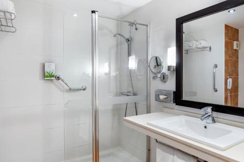 阿德耶日落港俱乐部钻石度假公寓的带淋浴、盥洗盆和镜子的浴室