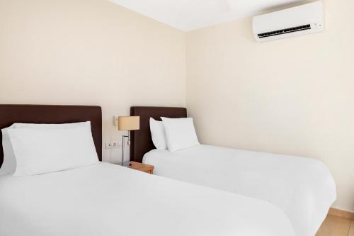 阿德耶日落港俱乐部钻石度假公寓的两张睡床彼此相邻,位于一个房间里
