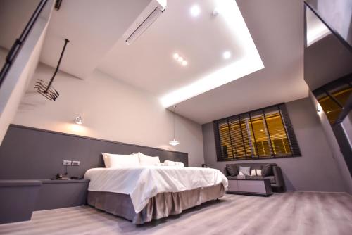 台南贰侣休闲艺术旅馆的一间卧室设有一张大床和一个窗户。