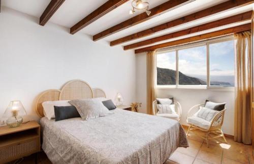 塔科龙特Experiences Salitre Suite的一间卧室设有一张床和一个大窗户
