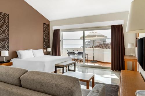 贝纳尔马德纳Sahara Sunset的酒店客房设有一张床,享有海景。