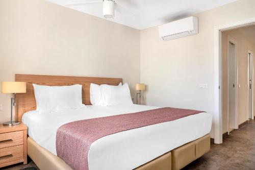 阿德耶日落湾俱乐部钻石度假公寓的卧室配有白色大床和白色枕头