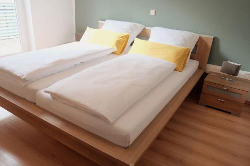 格恩斯巴赫Ferienwohnung Merkurblick的卧室内的两张床,配有白色和黄色枕头