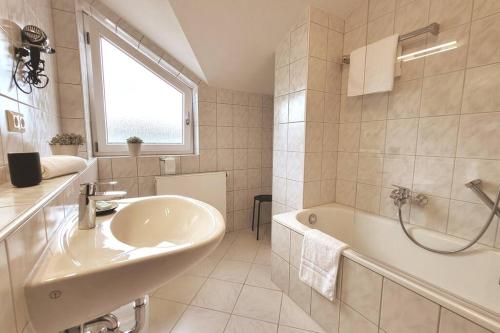 格恩斯巴赫Ferienwohnung Merkurblick的白色的浴室设有水槽和浴缸。
