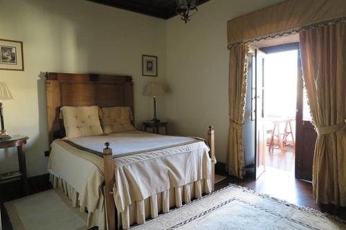 布拉干萨圣玛丽亚太阳旅馆的一间卧室设有一张大床和一个滑动玻璃门