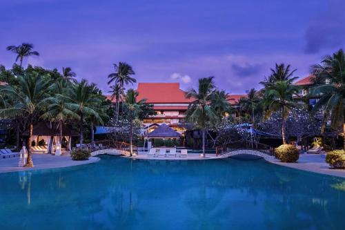 努沙杜瓦The Westin Resort Nusa Dua, Bali的棕榈树度假村的游泳池以及大楼