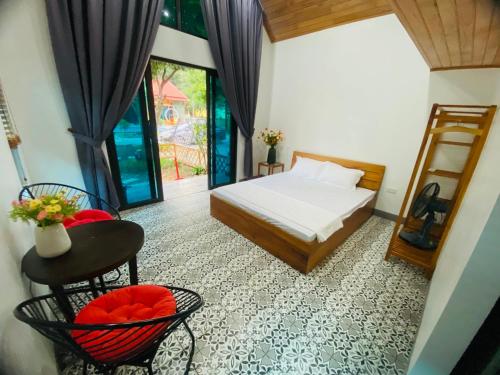 巴位Homestay Bài Văn garden的卧室配有一张床和一张桌子及椅子