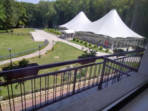 RazgradHotel Kovanlika 2的阳台享有花园的景致,配有白色帐篷。