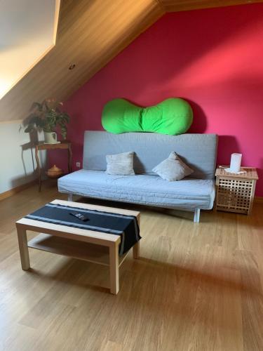 瑟兰Chambre d'hôtes le Vivaldi的客厅配有一张沙发,墙上挂着绿色枕头