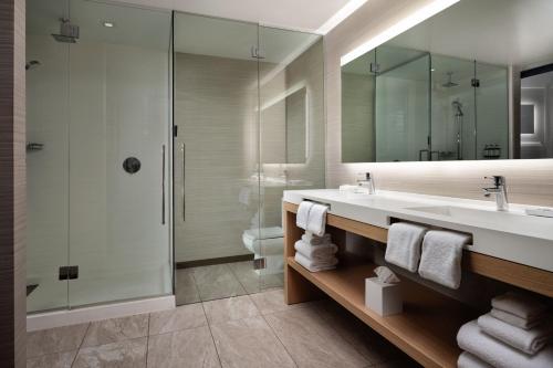 凤凰城AC Hotel by Marriott Phoenix Downtown的一间带水槽、淋浴和镜子的浴室