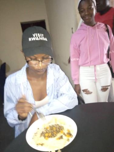 RUHENGELI,RWANDA的坐在餐桌上吃一盘食物的女人
