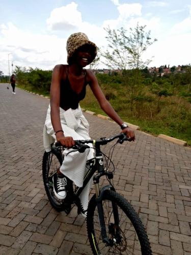 RUHENGELI,RWANDA的一位在砖路上骑着自行车的女人