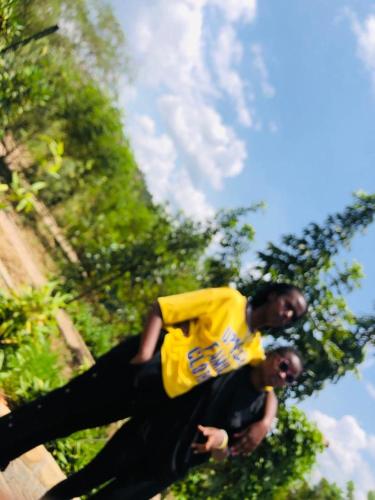 RUHENGELI,RWANDA的两个身穿黄衬衫的人站在一起