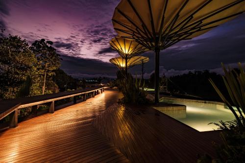 瓜塔佩Bosko的夜间带遮阳伞和游泳池的木板路