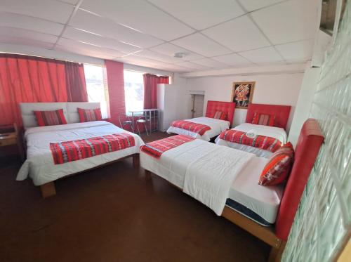 库斯科Hotel Plateros的带红色窗帘的客房内的三张床