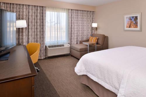埃尔森特罗汉普顿中心酒店的配有一张床和一把椅子的酒店客房