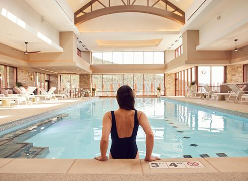 布莱克霍克Monarch Casino Resort Spa的坐在游泳池前的女人