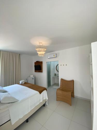 圣米格尔-杜戈斯托苏Monte Alegre Beach的一间卧室配有一张大床和一把椅子