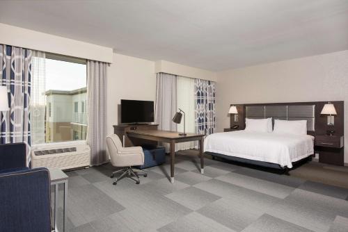 印第安纳波利斯Hampton Inn & Suites Indianapolis-Keystone, IN的酒店客房配有一张床、一张书桌和一台电视。