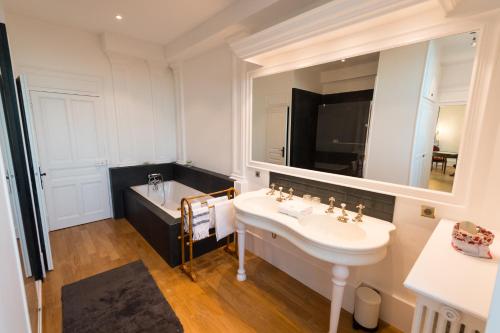 奥利韦Château du Rondon的一间带水槽、浴缸和镜子的浴室