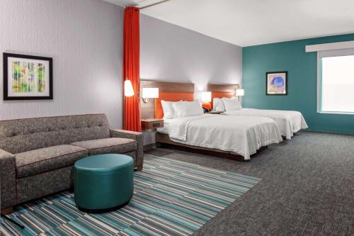 索尔兹伯里Home2 Suites By Hilton Salisbury的酒店客房,设有两张床和一张沙发