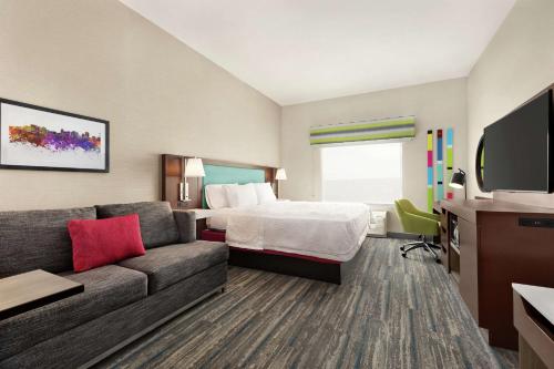 西瓦利城Hampton Inn West Valley Salt Lake City的酒店客房,配有床和沙发