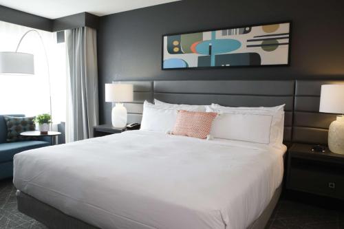 西得梅因多利西得梅因套房假日旅馆 的卧室配有一张白色的大床和一张沙发。