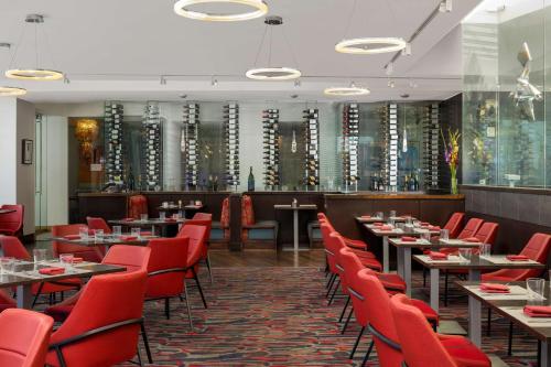 丹佛The Art Hotel Denver, Curio Collection by Hilton的用餐室配有桌子和红色椅子