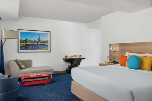 丹佛The Art Hotel Denver, Curio Collection by Hilton的酒店客房带一张大床和一把椅子