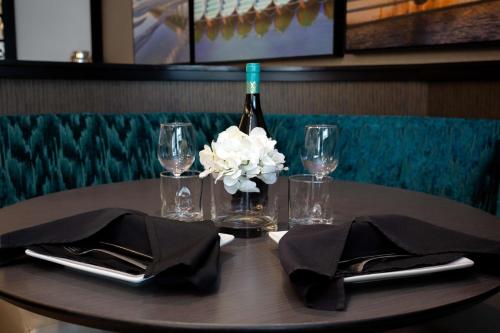 查尔斯顿DoubleTree by Hilton Charleston Mount Pleasant的一张桌子,上面放着一瓶葡萄酒和一朵花