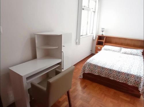 尤西德福拉Espaço exclusivo feminino的白色卧室配有床和书桌