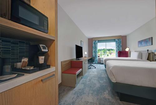 马纳萨斯Hilton Garden Inn Manassas的酒店客房,配有床和电视