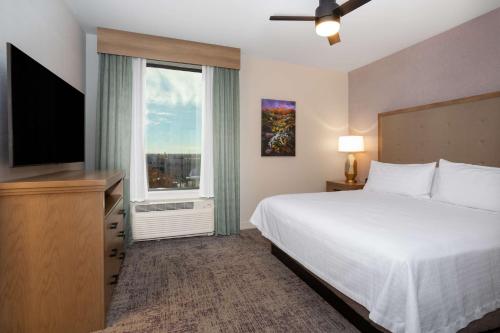 阿尔伯克基Homewood Suites By Hilton Albuquerque Downtown的一间卧室设有一张床和一个大窗户