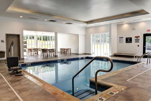 贝莱尔Hilton Garden Inn Bel Air, Md的大楼内带桌椅的游泳池