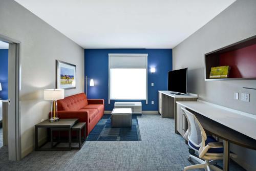 诺默尔Home2 Suites By Hilton Bloomington Normal的一间配备有沙发及电视的酒店客房