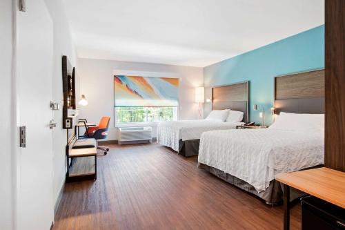 教堂山Tru By Hilton Chapel Hill的酒店客房设有两张床和窗户。