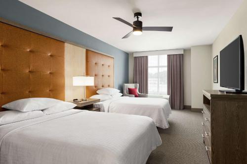 卡莱尔Homewood Suites By Hilton Carlisle的酒店客房设有两张床和一台平面电视。