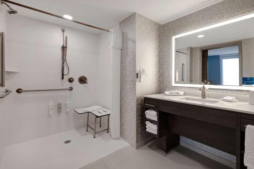 威克斯巴勒Home2 Suites By Hilton Wilkes-Barre的带淋浴、盥洗盆和镜子的浴室