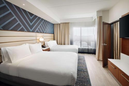亚特兰大Embassy Suites By Hilton Atlanta Airport North的酒店客房设有两张床和窗户。