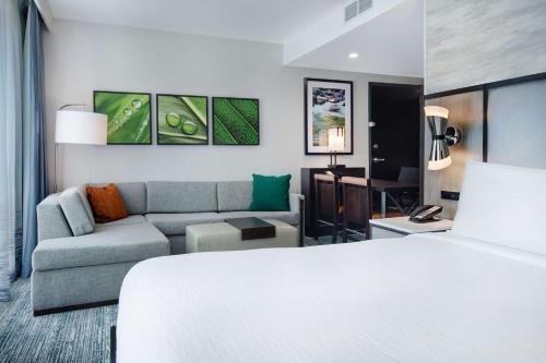 阿尔法利塔Embassy Suites By Hilton Alpharetta Halcyon的酒店客房,配有床和沙发