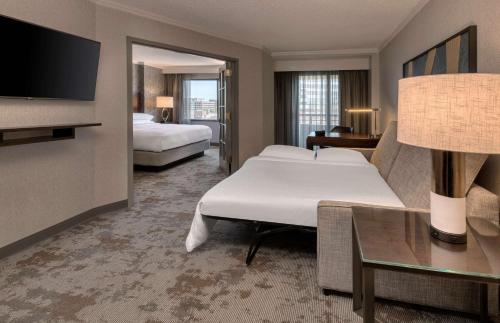 贝塞斯达Embassy Suites by Hilton Bethesda Washington DC的酒店客房设有两张床和一台平面电视。