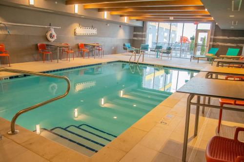 LogansportHome2 Suites By Hilton Logansport的大楼内一个带桌椅的游泳池