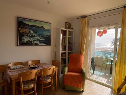 库尼特Cunit Beach的一间带桌椅和窗户的用餐室
