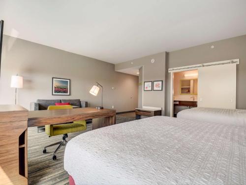 威廉斯敦Hampton Inn & Suites Williamstown Ark Encounter, Ky的酒店客房配有书桌和床。