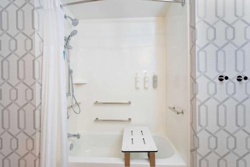 玛丽安娜Hampton Inn Marianna I-10的带淋浴和长凳的白色浴室