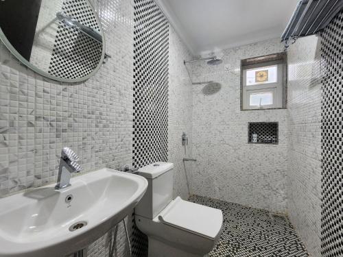 马焦茹达The Royal Oasis Goa的一间带水槽、卫生间和镜子的浴室