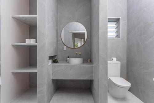 拉罗汤加Villa Varia的一间带水槽、镜子和卫生间的浴室