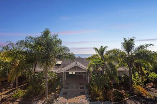 科纳Pu'ukala Sunset Estate with Amazing Ocean Views! home的前面有棕榈树的房子